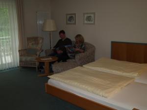 巴特皮尔蒙特福雷德利克斯帕克酒店的坐在有床的房间的男女