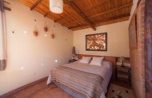 胡阿卡勒拉索拉特洛匹克旅馆的一间带一张床的卧室,位于带木制天花板的房间内