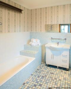 肯图巴回声点别墅的蓝色的浴室设有浴缸和水槽