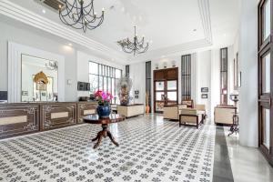 登巴萨巴厘岛英娜遗址酒店的一间铺有瓷砖地板并配有桌子的大客厅