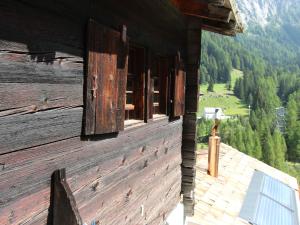 SaflischmattenBeautiful Chalet in Binn with Parking的木结构一侧的开放式窗户