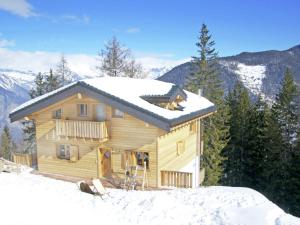 拉茨欧马兹Charming chalet in La Tzoumaz with open fireplace的雪中小木屋,背景是群山