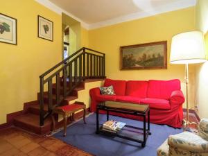 Tagliolo MonferratoBelvilla by OYO Nobile的一间带红色沙发和楼梯的客厅