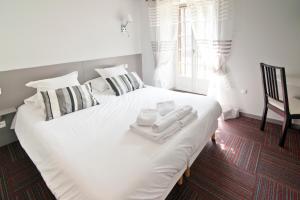 奥尔西瓦勒卡托客栈 - 罗氏酒店的卧室内的白色床、毛巾和椅子