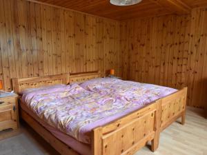 Grengiolsdetached holiday home in Grengiols Valais views的木墙客房内的木床