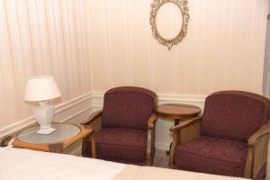 哈瑟尔特避难所B＆B旅馆的一间设有两把椅子、一张桌子和一面镜子的房间