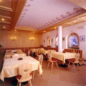 塞尔瓦迪加尔代纳山谷斯库亚图罗酒店的用餐室配有桌椅