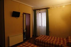 利亚内斯伊比利亚旅馆的一间卧室配有床和带窗帘的窗户