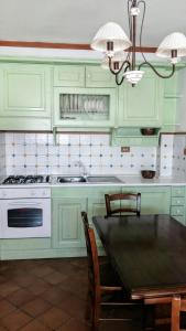 罗卡拉索Number 51的厨房配有绿色橱柜、桌子和炉灶。