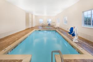 PerryMicrotel Inn & Suites by Wyndham Perry的室内的蓝色海水游泳池