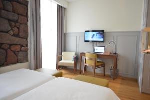 波尔图镇Charming Blue的酒店客房配有一张床和一张带电脑的书桌