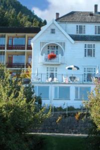 巴里斯川米缇恩斯酒店的带阳台和遮阳伞的大型白色房屋