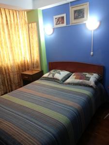 AbancayHostal Arcangel的一间卧室设有一张床和蓝色的墙壁