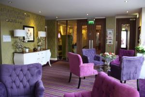 贝尔马利特塔尔波特酒店的一间设有紫色椅子和一张桌子的等候室