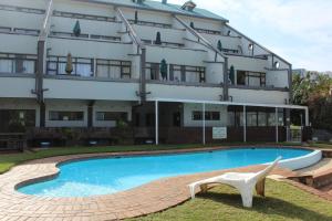 马盖特Dumela Margate Flat No 2的大楼前设有游泳池的酒店