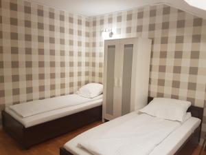 华沙杜斯卡旅馆的带格子墙的客房内的两张单人床