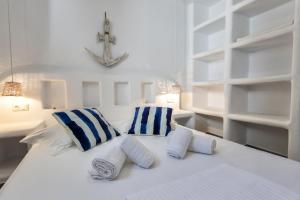 米科利维亚Casa Perla的白色的床和蓝色的白色枕头