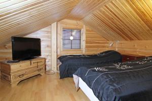 Hollola梅西拉营地酒店的一间小屋内带两张床和电视的房间