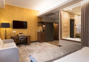 塔尔图V温泉会议酒店的酒店客房配有一张床、一张书桌和一台电视。