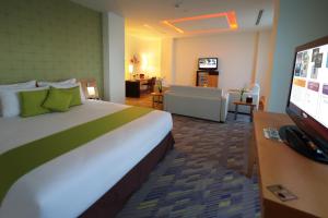 达曼达曼商业园诺富特酒店的酒店客房设有一张大床和一间客厅。