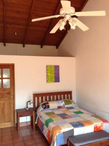 科潘玛雅遗址La Casa de Don Santiago Townhouse的一间卧室配有一张床和吊扇