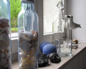 维斯马威乐特酒店的架子上装有贝壳和玻璃碗的花瓶