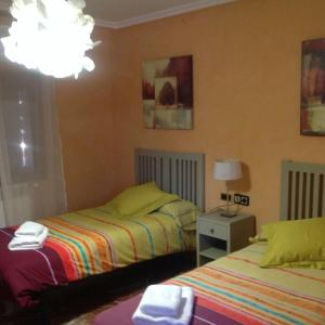 Torres de BarbuésCasa Valfonda的一间卧室配有两张床和一盏灯