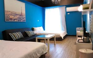 南湾盛夏垦丁轻旅的客房设有床、沙发和窗户。