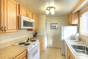 新港Little Creek Cove Beach Resort的厨房配有木制橱柜和白色冰箱。