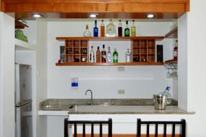 通贝斯HOTEL Casa cesar的厨房配有水槽和一些放在架子上的瓶子