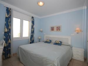 奥利瓦奥利维亚诺瓦别墅的一间卧室配有一张蓝色墙壁的床和一扇窗户