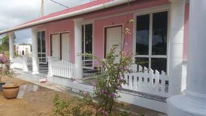 瓜拉勿述伊泽2号经济旅馆的粉红色和白色的房子,设有门廊