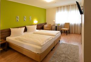 特里尔Hotel L' Angolo的一间卧室设有一张大床和绿色的墙壁