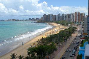 福塔莱萨Bourbon Fortaleza Hotel Beira Mar的享有海滩、建筑和大海的景色