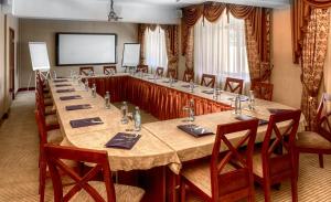 阿拉木图远航酒店的大型会议室,配有长桌子和椅子