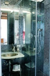 斯培西亚洛堪达特拉蒙蒂酒店的一间带玻璃淋浴和水槽的浴室