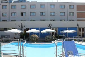 卡斯泰尔菲达尔多克拉斯酒店的酒店前方的游泳池配有椅子和遮阳伞