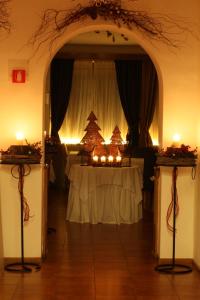 科尔蒂纳丹佩佐特里雅特酒店的一间设有一张桌子的房间,配有圣诞树和蜡烛
