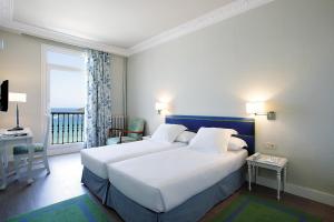 圣塞瓦斯蒂安妮扎酒店的一间带一张白色大床的卧室和一个阳台