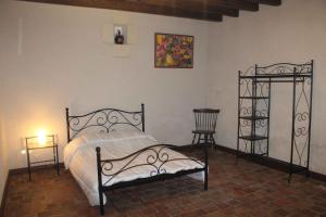圣艾尼昂迷人小屋度假屋的一间卧室配有锻铁床和两把椅子
