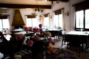 UlldeconaHotel Bon Lloc的桌子上摆放着桌子和鲜花的房间