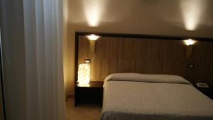 曼恰诺罗西酒店的卧室配有一张床,墙上设有灯。