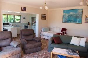 泰哈皮Llanerchymedd的带沙发和椅子的客厅以及厨房。