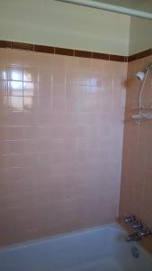 阿拉莫戈多白沙汽车旅馆的带浴缸的浴室和粉红色的瓷砖墙