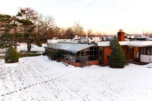 纽堡Newburgh Inn的雪中的房子,有雪覆盖的院子