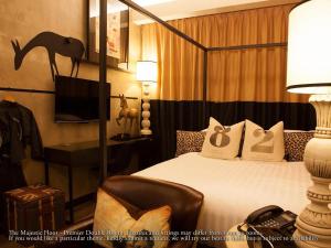 怡保M精品酒店的一间卧室配有一张床、一张书桌和一台电视。