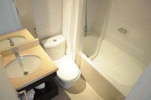 圣地亚哥Kennedy Apartments Los Militares的浴室配有卫生间、盥洗盆和浴缸。