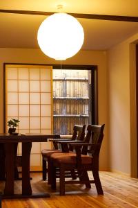 京都Kyoyado Hakuto的用餐室配有桌椅和灯具
