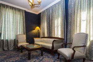 第比利斯Hotel Astoria Tbilisi的客厅配有沙发、两把椅子和一张桌子