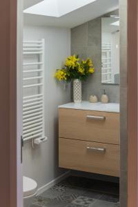南希Appartement 9 Place d'Alliance的浴室设有水槽和黄色花瓶
